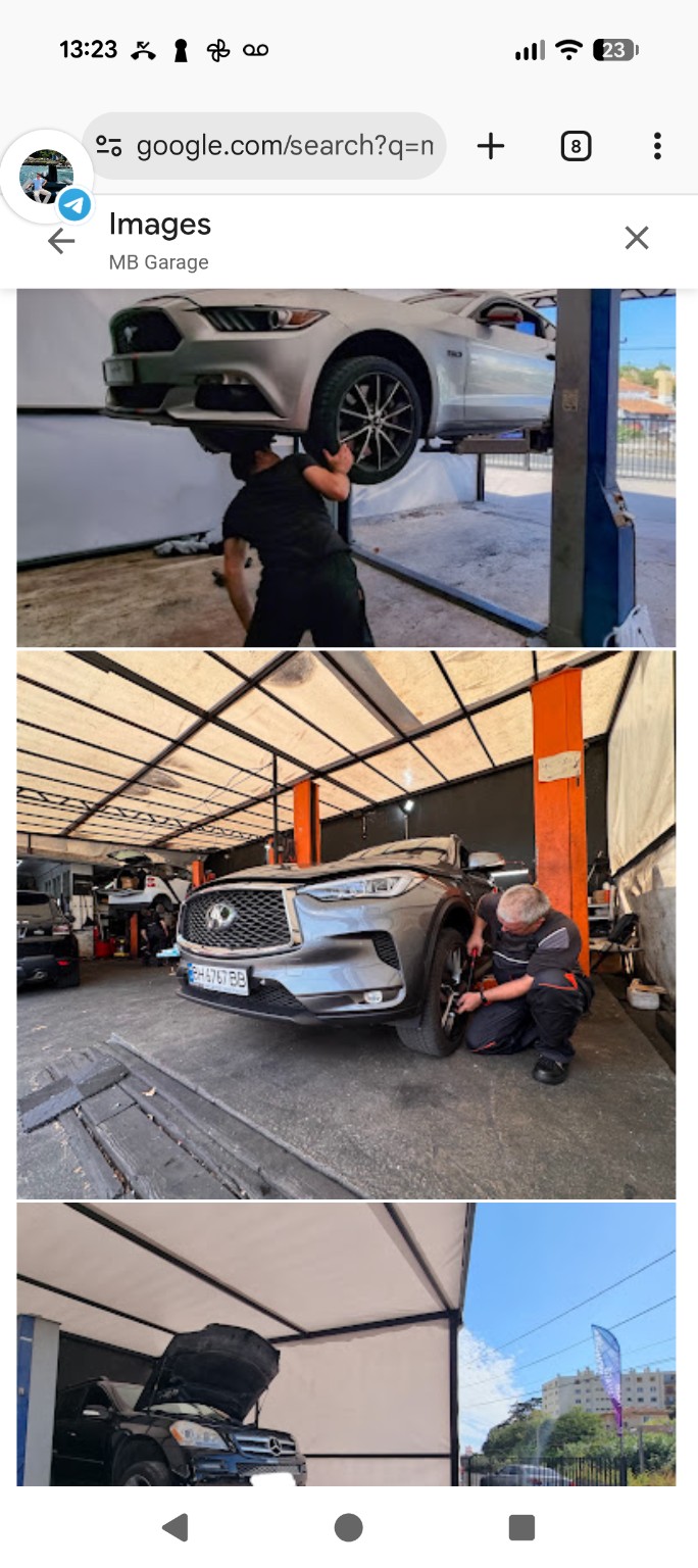 Un mécanicien travaille près de la roue avant d’un Infiniti dans l’atelier.